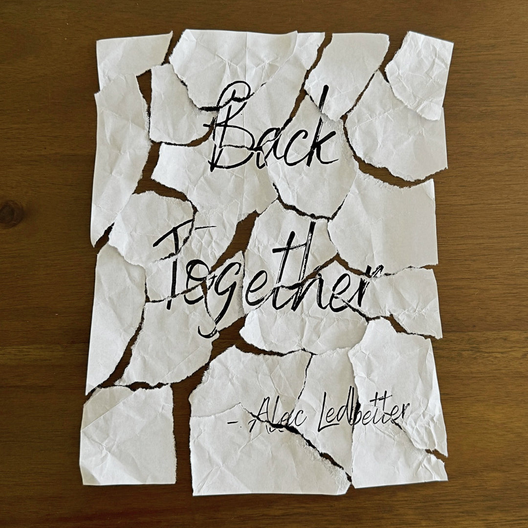 Album art for the song Back Together by Alec Ledbetter of a ripped up piece of paper with the title of the song and a on a wood table.